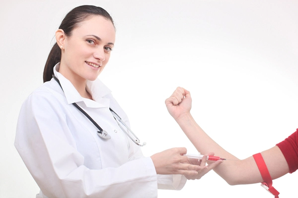 a woman doctor with a syringe is taking blood for tests