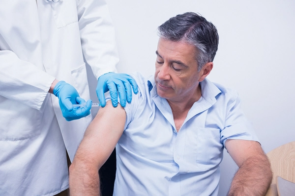 doctor giving injection to his patient at the hospital