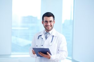 smiling doctor with clipboard and stethoscope looking at camera SBI 305497329 300x200
