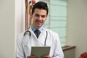 Young doctor holding pad with both hands 300x200