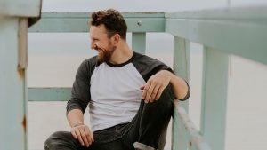 A happy man sitting on a beach