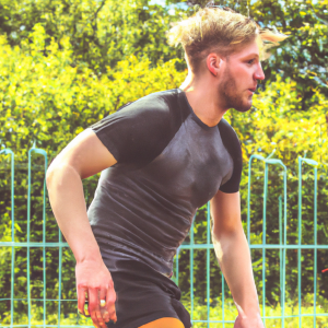 a professional appealing good looking and atheletic image of a caucasian man exercising or playing sports outside on a sunny day